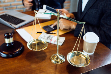Justice and law concept.Male judge in a courtroom with the gavel, working with, computer and docking keyboard, eyeglasses, on table in morning light