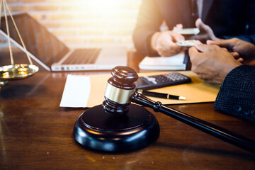 Justice and law concept.Male judge in a courtroom with the gavel, working with, computer and docking keyboard, eyeglasses, on table in morning light