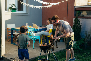 father and son preparing fire for barbecue at home