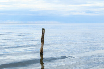 Fototapeta premium Sea scenery with broken pier pole sticking from water.