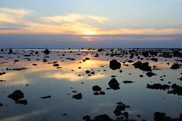 Fototapeta na wymiar Sunset on the beach - scenic seascape with rock during the low tide.