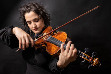 Beautiful girl professional violinist playing antique violin
