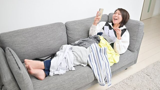 家事の合間に動画を楽しむ女性　お菓子を食べる動画