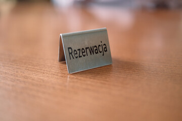 Iron reserved sign with capital letters on dining table in restaurant.