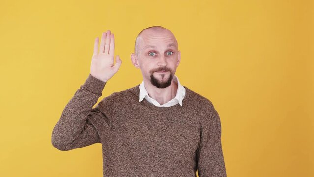 Bye gesture. Leaving farewell. See you. Boomerang animation. Friendly smiling funny man waving hand goodbye gif loop isolated on orange empty space background.