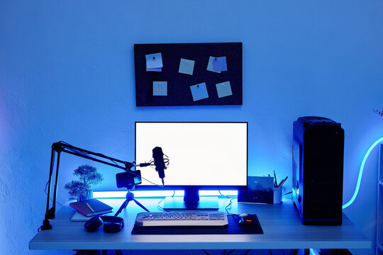 Background image of gaming setup PC on desk lit with blue neon lighting, screen mockup