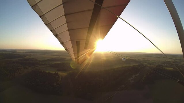 hang gliding around a balloon at sunset