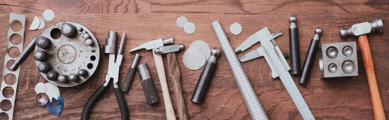set of various tools placed on a wooden desk in a workshop banner