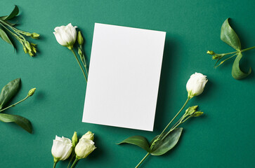 Invitation or greeting card mockup with white eustoma flowers on green