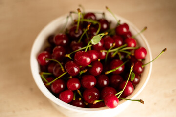 Obraz na płótnie Canvas Close up of many ripe red cherries in a white bowl.