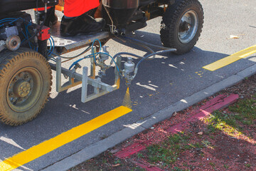 Road workers use hot-melt scribing machines to painting pedestrian crosswalk on asphalt road...