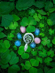 clover leaves, gemstones and witch amulet with pentagram on natural forest background. crystals set...