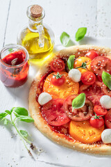 Delicious and homemade pizza Margherita with various tomatoes and mozzarella.
