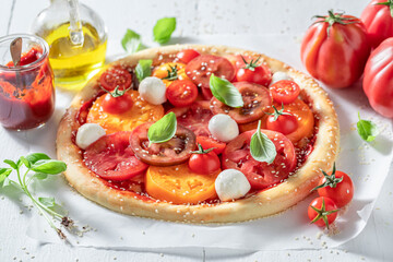 Fresh and tasty pizza Margherita with various tomatoes and mozzarella.