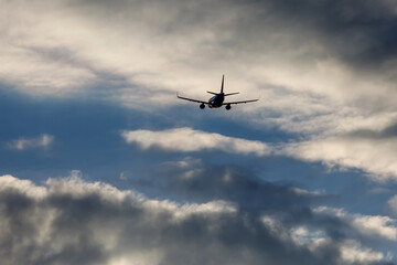 Naklejka na ściany i meble Airplane in the cloudy sky.