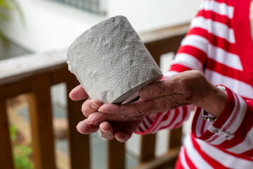 older woman holding a role toilet paper in her hands