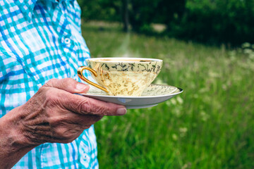 close-up of an older woman holding a tea cup