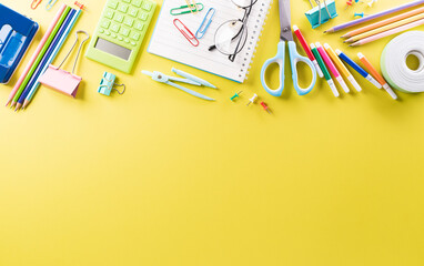 Education or back to school Concept. Top view of Colorful school supplies with books, color pencils, calculator, pen cutter clips and apple on pastel paper background.