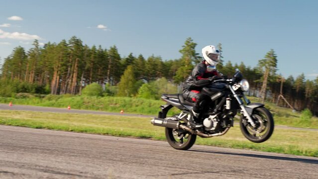 Revving up motorcycle with wheelie on racetrack at Latvia