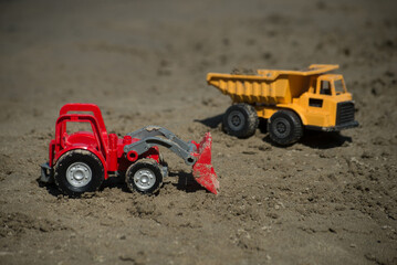 Closeup of construction trucks toys on the beach