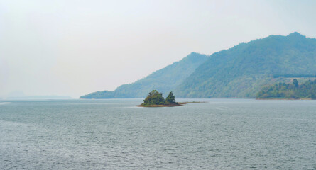 Aerial top view of small island in lake or sea in national park and mountain or hill in summer...