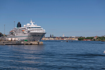 Fototapeta na wymiar Tourist cruise ship at the pier Masthamnen and the skyline of the old town Gamla Stan a sunny summer day in Stockholm 