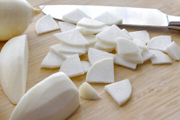 Sliced radish on a bamboo chopping board. 