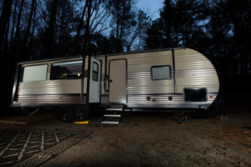 Night travel trailer in a forest