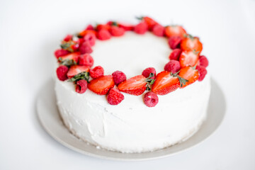 Delicious biscuit cake with cream cheese and berries. Light cake with strawberries and raspberries. Handmade cake. close up, copy space background