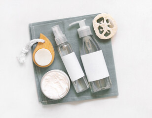 Homemade Cosmetics in plastic jars and bottles on grey towel top view on white. Mockup.