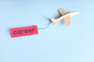 Career launch and take off concept. Wooden airplane model with red banner.