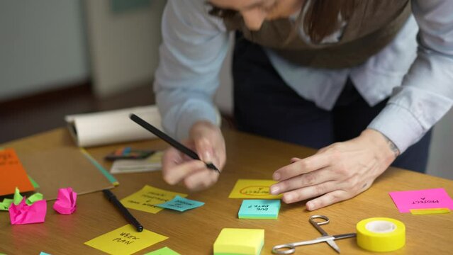Professional woman working on her brand strategy. She is writing in post it notes.
