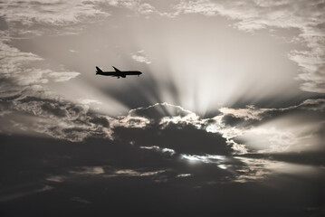 Plane and Dramatic Sun behind the Clouds 1