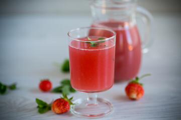 Cold summer strawberry kvass with mint in a glass