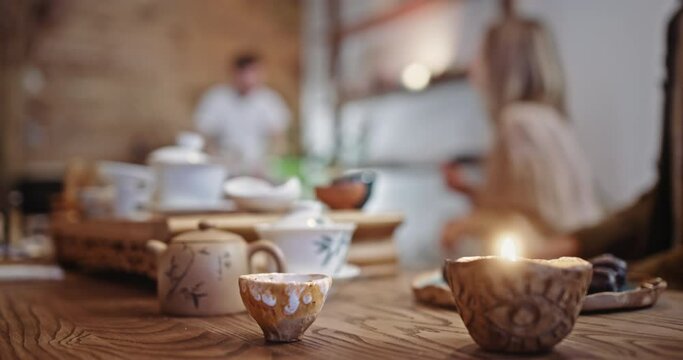 Ancient bowl stands on wooden table against people in cafe