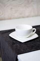 Empty white tea cup and saucer on the table. Porcelain dishes, selective focus.