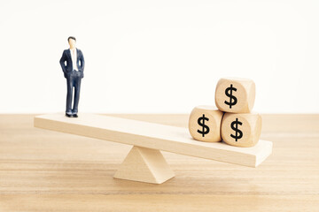 Life and Work or money balance concept. Businessman figurine and dollar symbol on wooden blocks on...