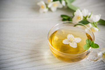 Obraz na płótnie Canvas Composition with cup of jasmine tea and flowers