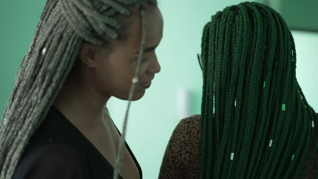 Two black female friends with box braids hairstyle. Young latina women with braided hair