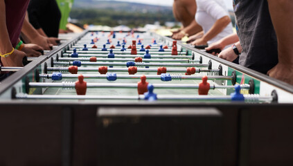 Foosball fanatics. Cropped shot of a group of people playing foosball.