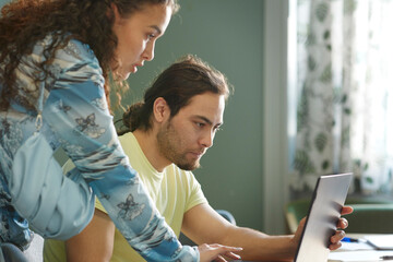 Coworkers in boardroom using laptop
