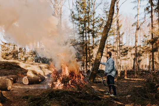 Man burning branches in forest