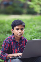 Portrait of Indian boy using laptop while attending the online classes