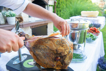 Slicing dry-cured ham prosciutto