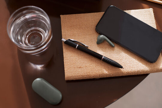 Smartphone and earbuds on notebook