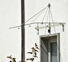 Rahmenloses Glas-Vordach, abgehängt an Edelstahl-Streben, an einem Wohnhaus