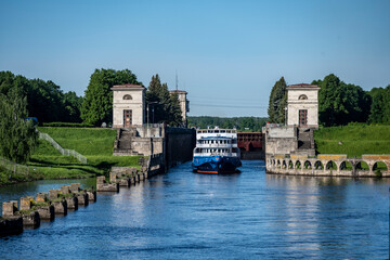 Fototapeta premium river boat passes through the lock on the river on a summer day