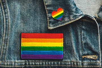 Close-up of LGTBI flag textile patch on a denim jacket and LGTBI pin heart shaped. Pride day concept