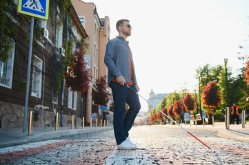 Blind young man crossing road