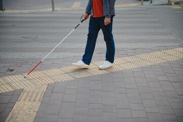 Blind Man Walking On Sidewalk Holding Stick